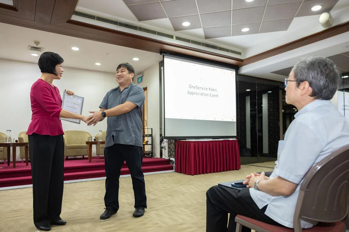 外交部兼国家发展部高级政务部长沈颖（左一）在活动上颁发奖状给淡马锡理工学院应用行为中心主管陈华彪博士（左二），以表彰淡马锡理工学院的社区贡献。（海峡时报）