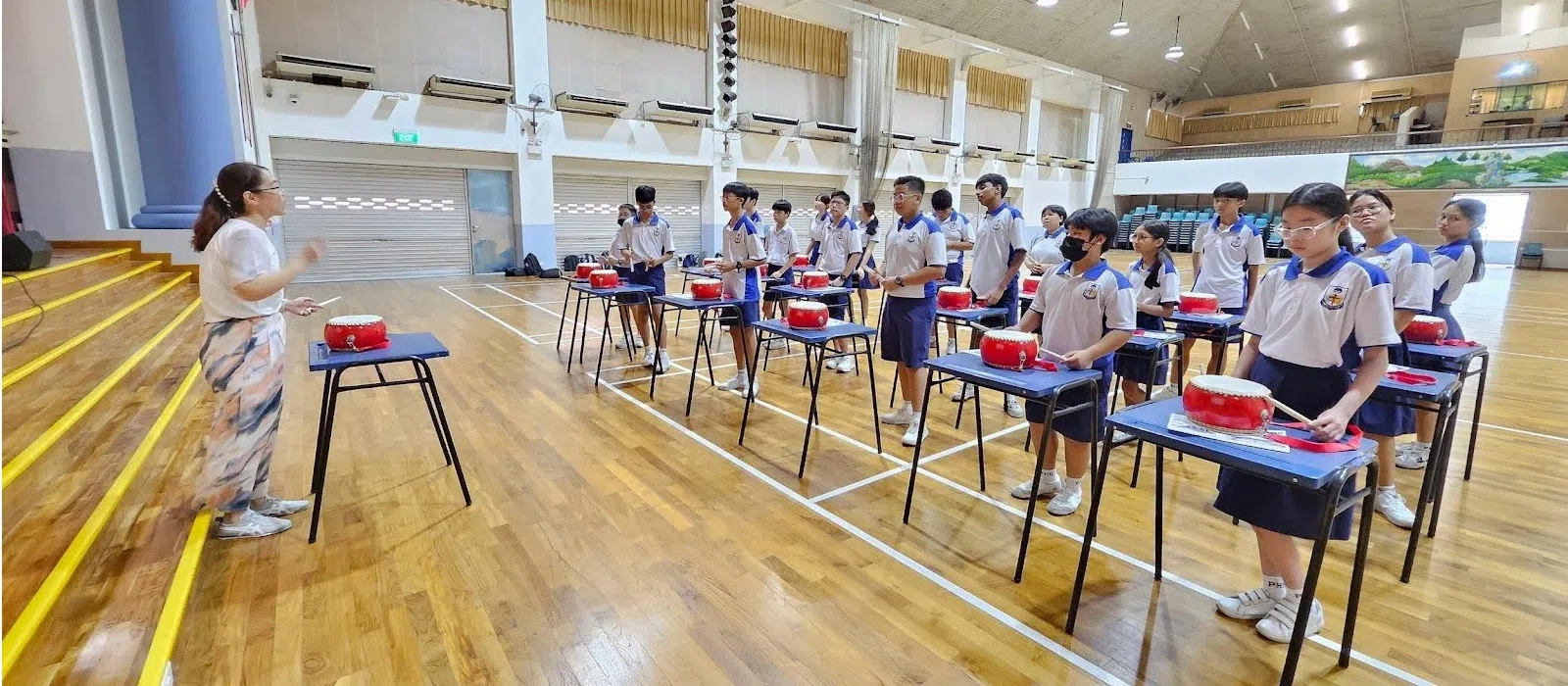 学生在专业指导下学习如何打二十四节令鼓。（长老会中学提供）