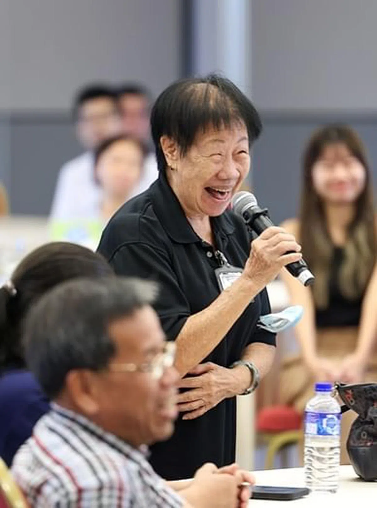 81岁清洁工萧惠娇与对话会参与者分享自己在工作上的故事。（关俊威摄）