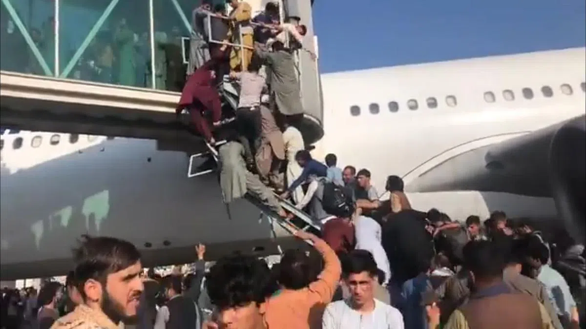 为了能上飞机，很多人争先恐后爬上登机桥，场面失控。（取自推特）