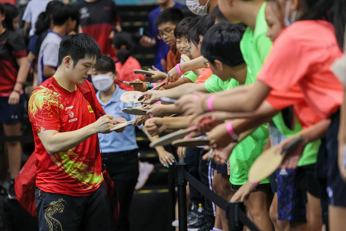 世界第一的樊振东赛后给几个小朋友签名。（卓祾祎摄）
