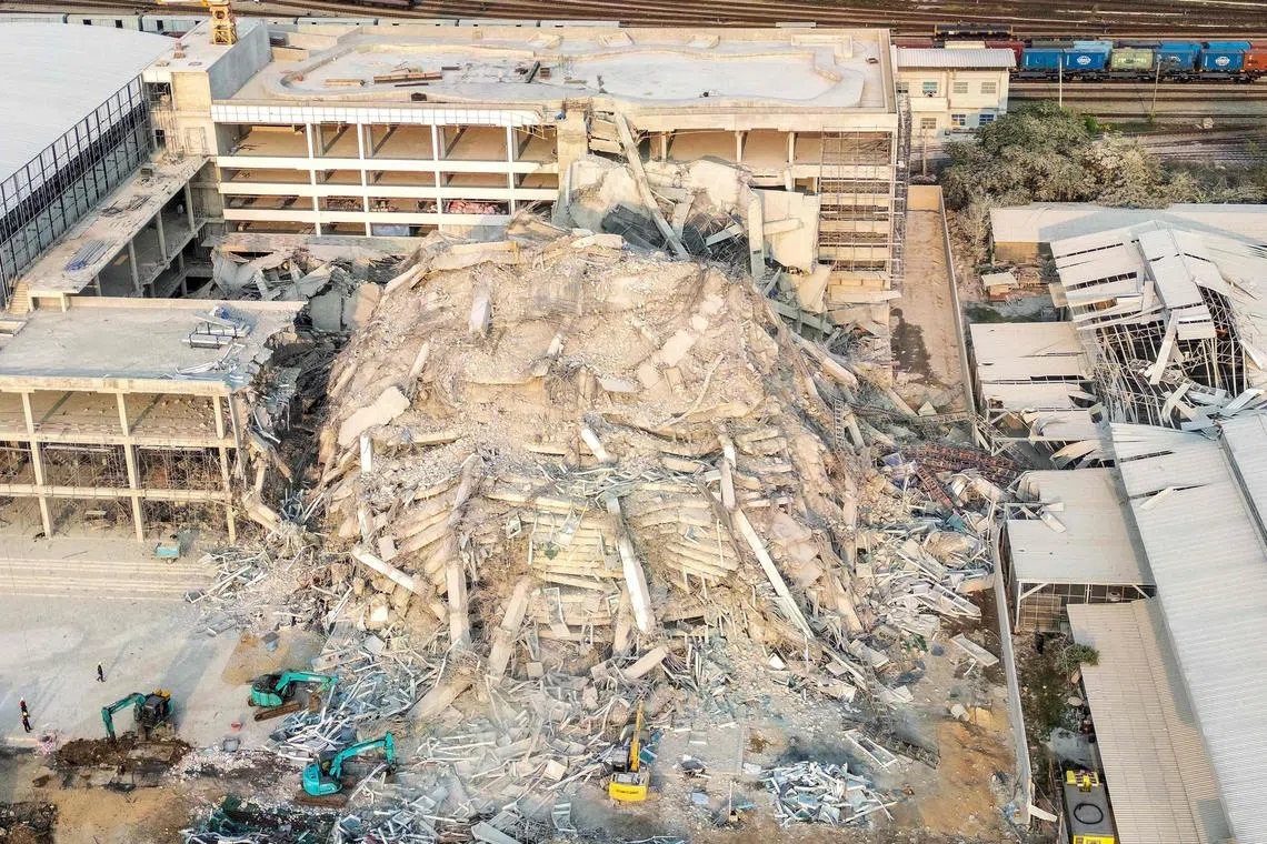 曼谷一座建造中的30层高大楼在几秒钟内化为废墟，多达百名工人下落未明。（法新社）