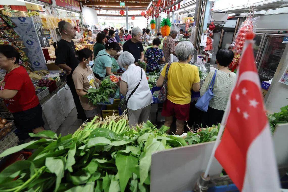 农历新年临近，消费者提前采购年菜食材，不少摊位从早上就开始忙碌，不管是蔬菜摊、海鲜摊或鸡肉摊前都挤满人。（梁麒麟摄）