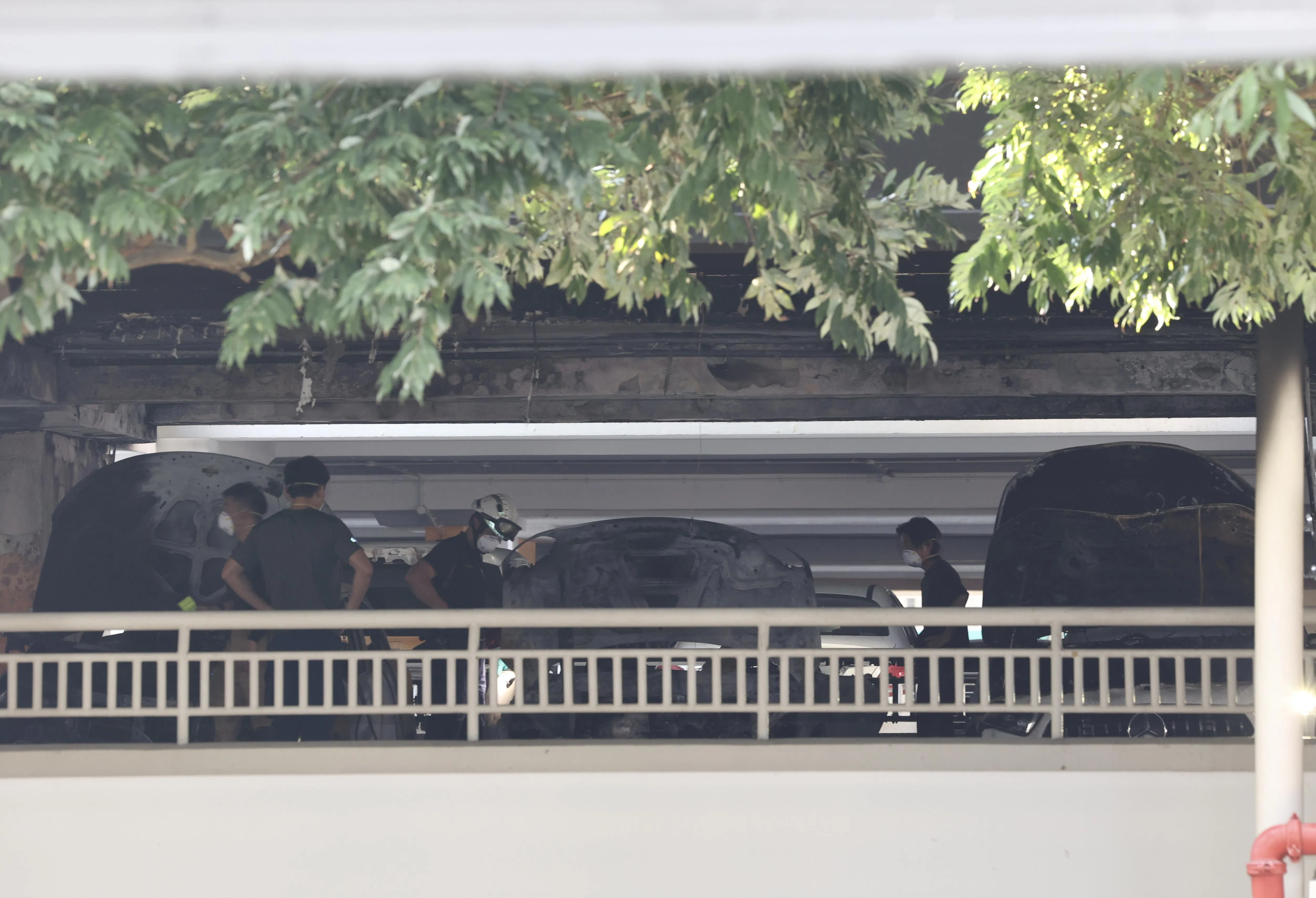 火势扑灭后，民防部队人员在失火车辆周围展开调查。（邬福梁摄）