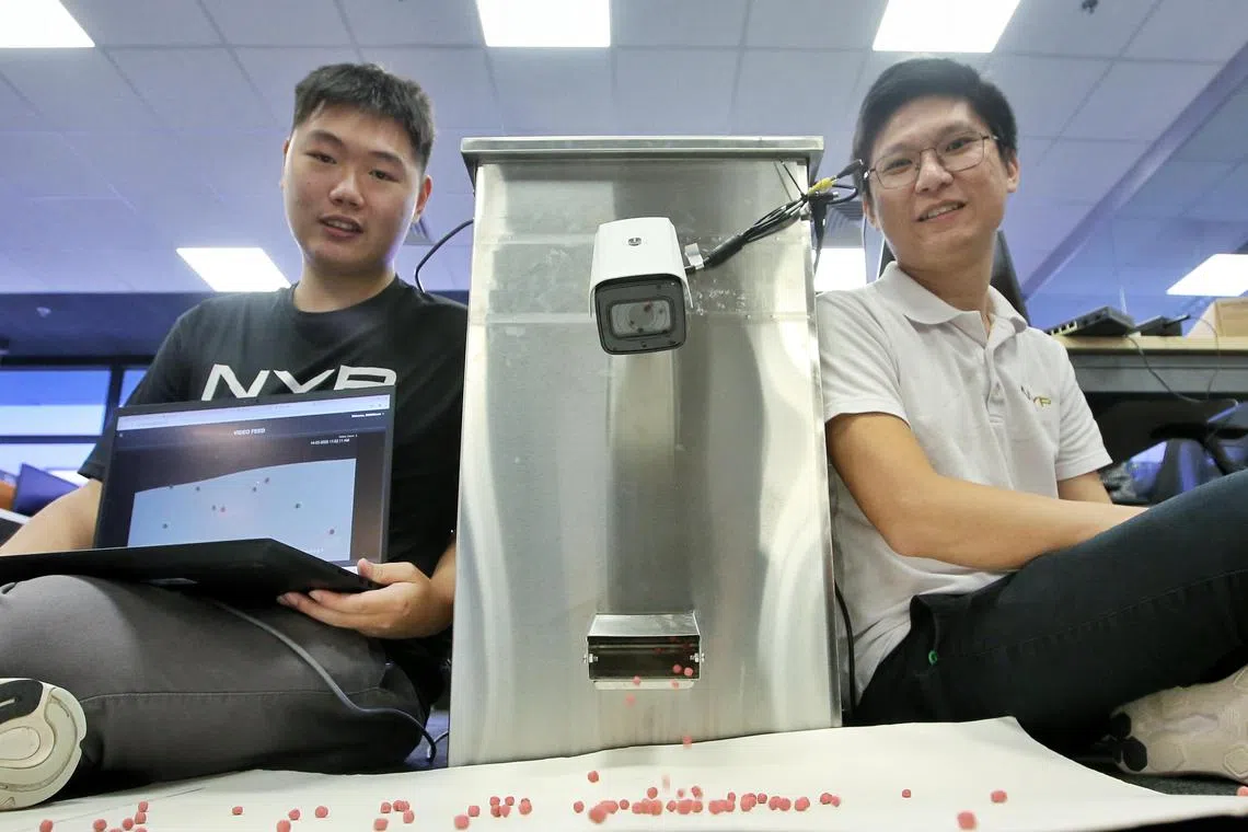 资讯科技学院讲师罗朝丰（右）带领学生叶浚哲参与研发的智能水产投喂系统，可记录每次投喂后的饲料数据，帮助养殖场精准掌握投喂情况，并根据前一天的数据优化饲料使用。（特约摄影陈福洲）