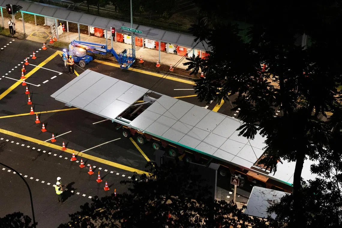 一座重达七公吨、长26米、宽五米的屋顶结构，由拖车运抵现场，随后由起重机吊起，并安装在四根支柱上。（蔡家增摄）