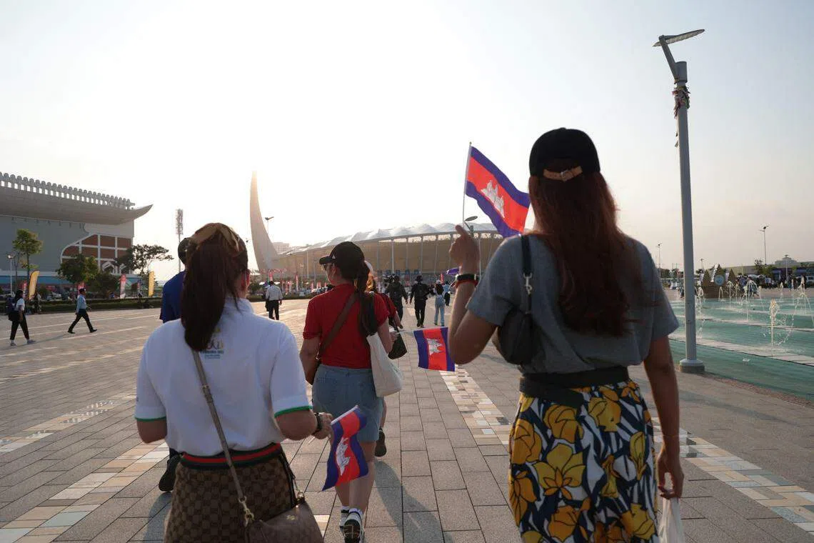 开幕仪式开始前，民众挥着国旗进入体育馆。（李冠卫摄）