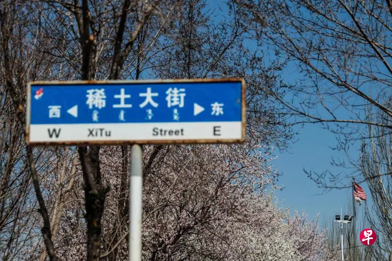 4月6日，在中国稀土产业重镇内蒙古包头市，稀土大街旁竖立着路牌，背景中可见中国和美国国旗。 （路透社）
