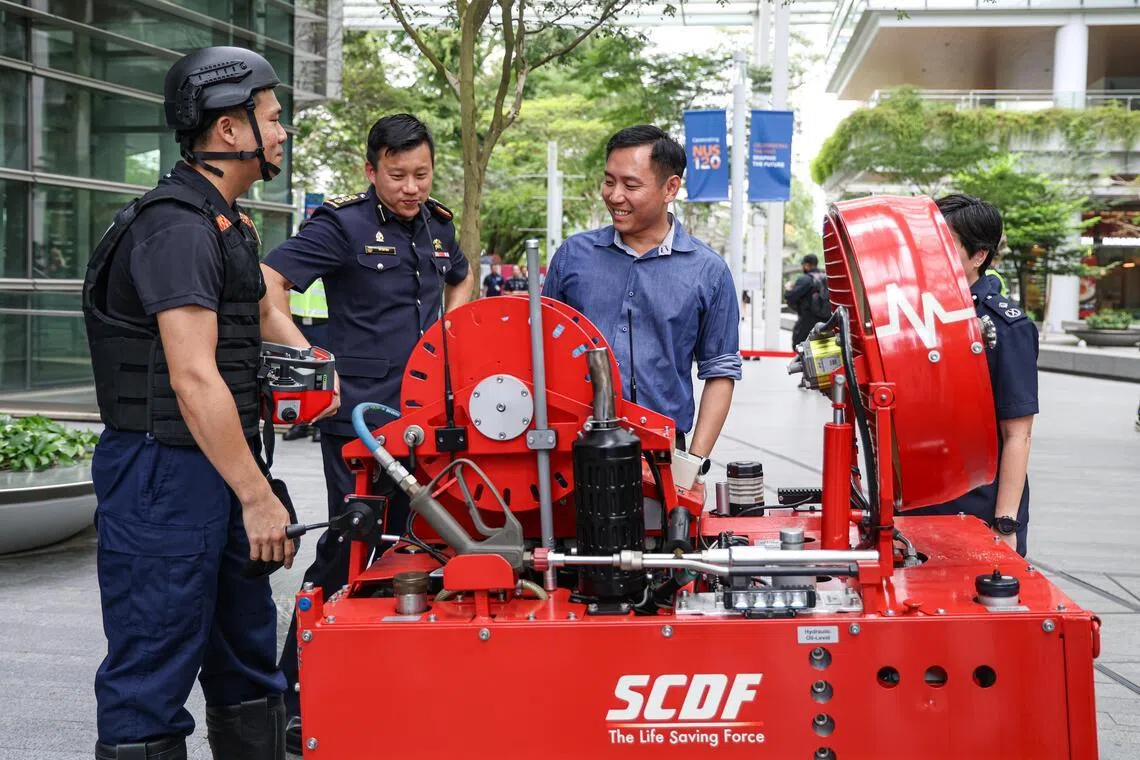 社会及家庭发展部兼内政部政务部长吴培铭（左三）在演习结束后，与参与演习的民防人员交谈。（关俊威摄）