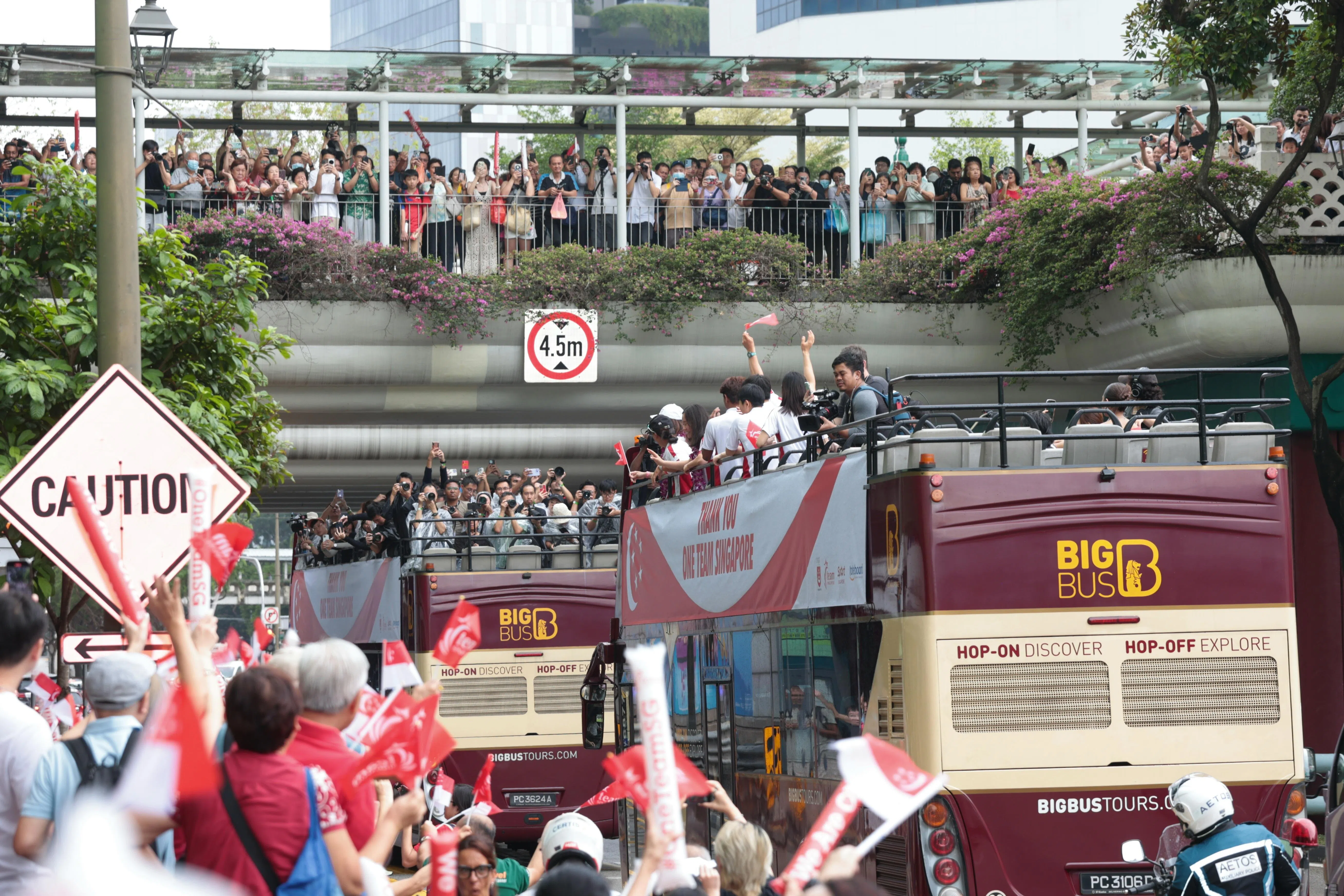 许多民众在路边和天桥上向我国健儿挥手。（梁麒麟摄）