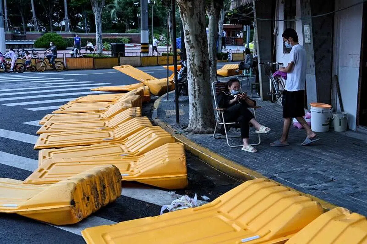 图为上海静安区市民站在障碍物旁，据当地居民说，这些障碍物是上海市官方在封城期间用来封锁疫情重灾区，但昨天下午均已被拆除。（法新社）