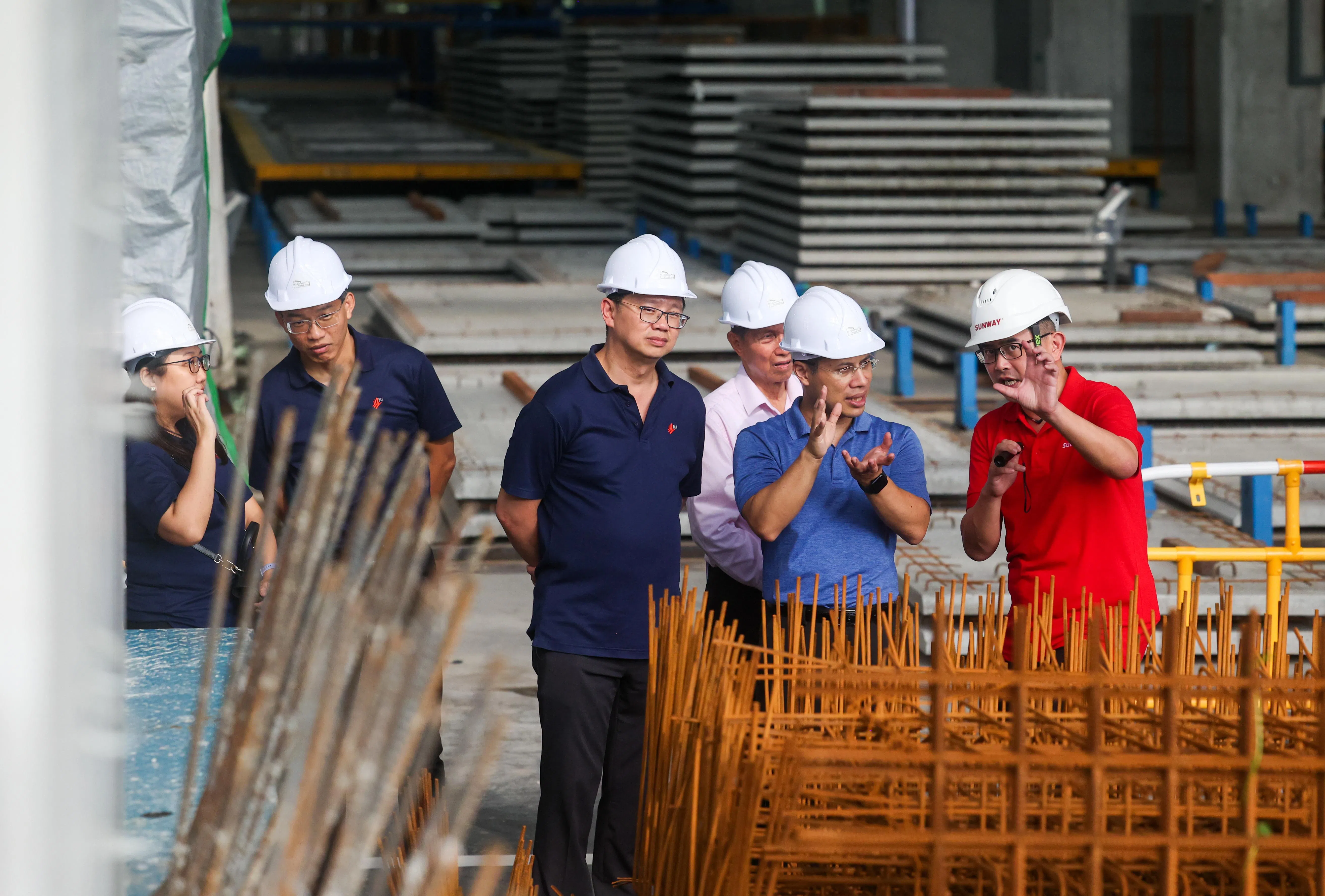 国家发展部长李智陞（右二）向双威建筑集团负责人了解建设预制枢纽的运作，在他身旁的是建设局副局长梁俊强。（陈斌勤摄）