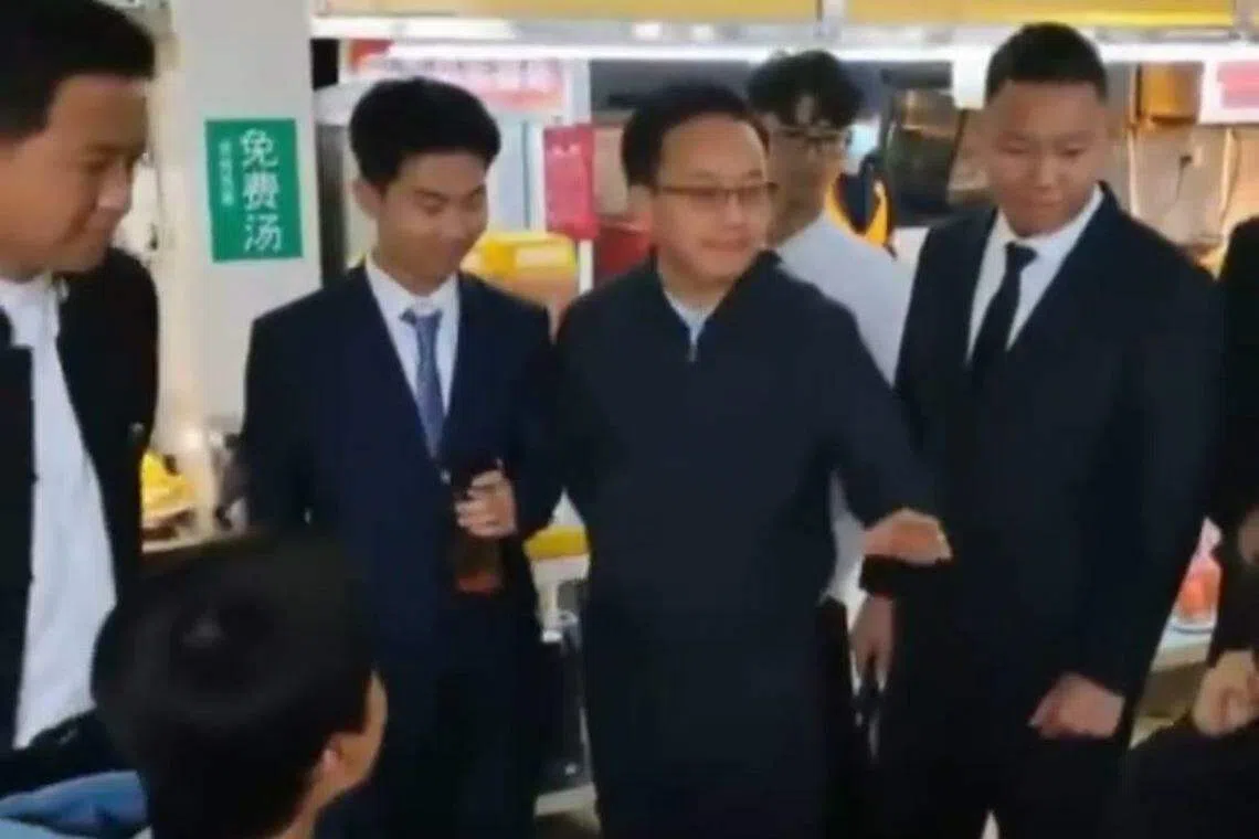 学生模仿领导的样子与就餐学生进行交谈。（视频截图）