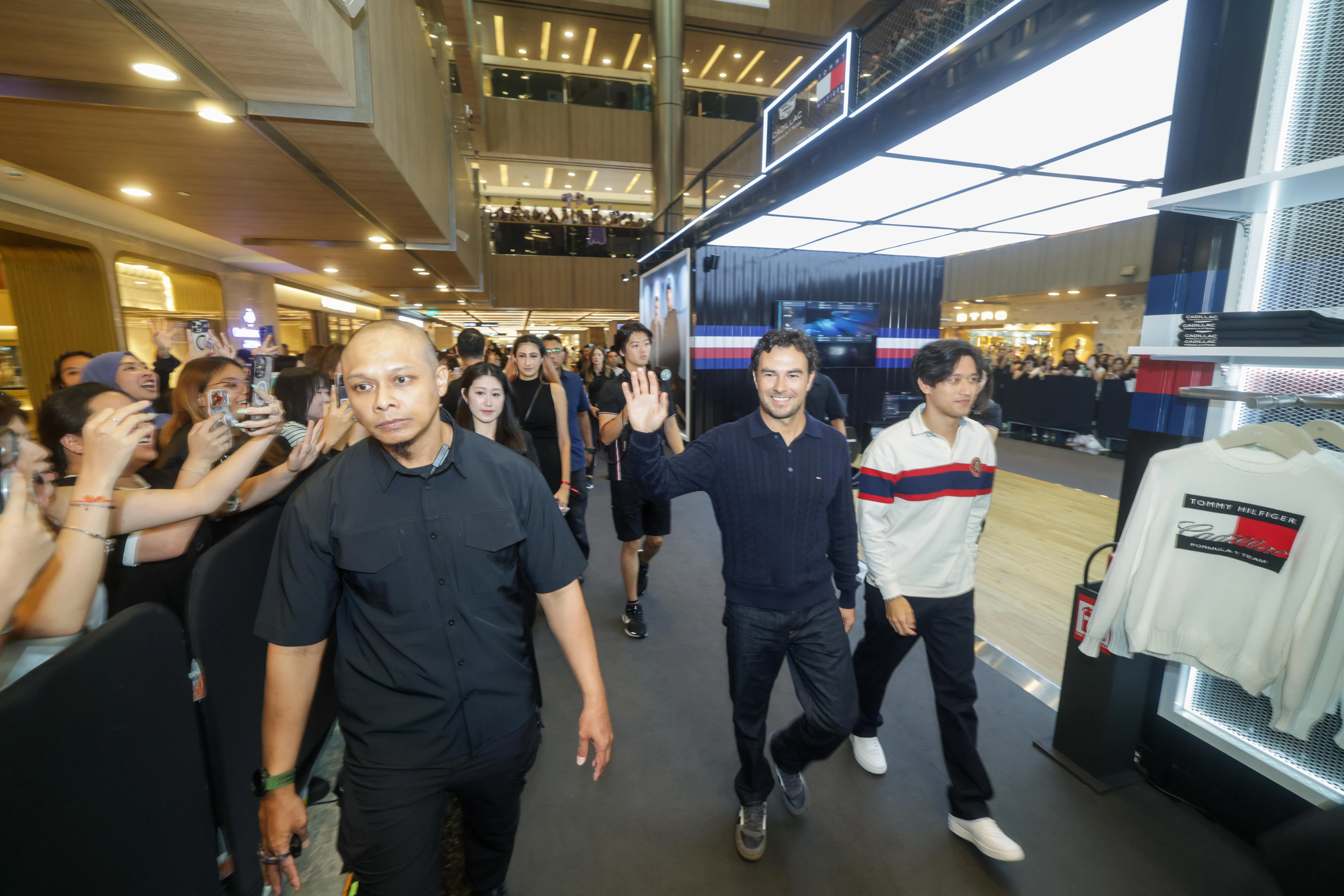 周冠宇（右）和队友佩雷兹（中右黑衣）在本地都有大量粉丝，他们的出现引爆了现场车迷的热情。（吴先邦摄）