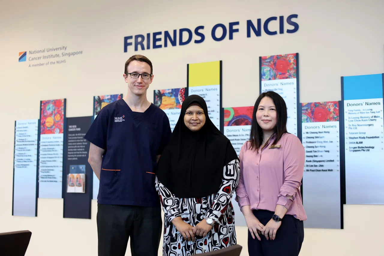 结肠直肠癌患者诺丽莎（中）感谢罗伯特医生（左）与社工赖诗婷（右）在抗癌路上提供的各种支援。（龙国雄摄）