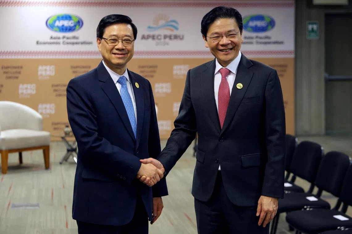 总理兼财政部长黄循财（右）在秘鲁出席亚太经合组织峰会期间，与香港特首李家超（左）会面。（数码发展及新闻部）