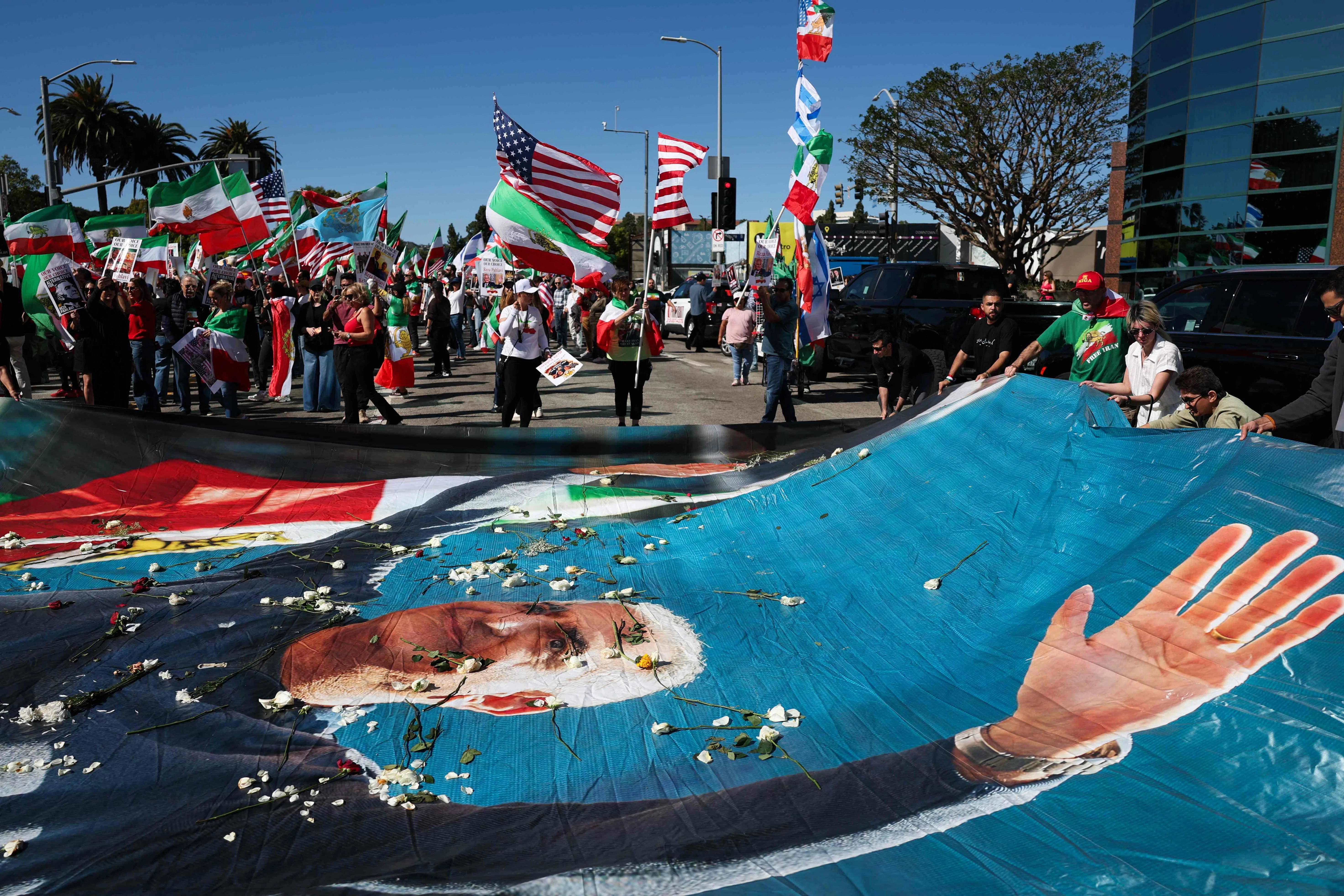 在加利福尼亚州洛杉矶的西木联邦大楼外，示威者举着伊朗前王储礼萨·巴列维的横幅，与伊朗社区成员聚集在一起，支持伊朗政权更迭。（法新社）