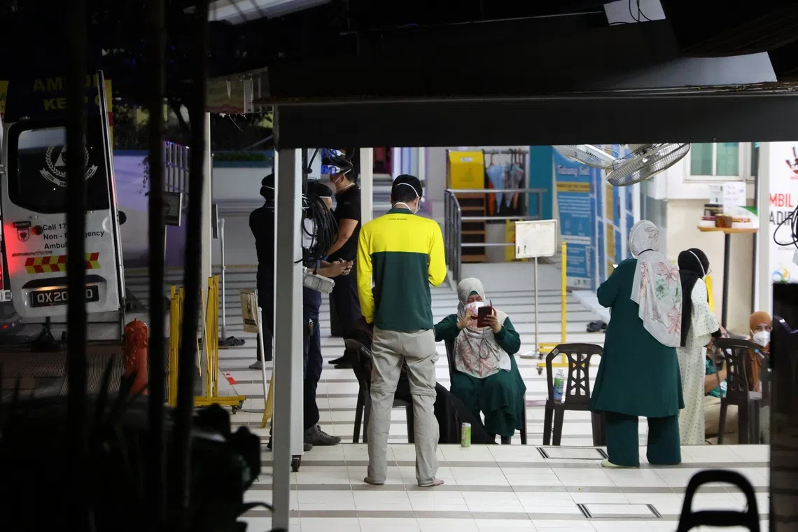 依斯迪阿马回教堂职员戴着口罩集合在教堂门口，等待民防人员调查教堂内发现的可疑包裹。（梁麒麟摄）