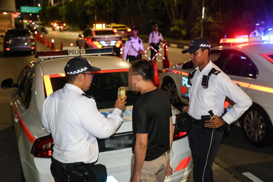 交警会视情况拦下一些车辆，驾驶者得先通过吹气进行初步酒测。若初步测试不过关，驾驶者则须到一旁设立的临时站点再接受测试。（关俊威摄）