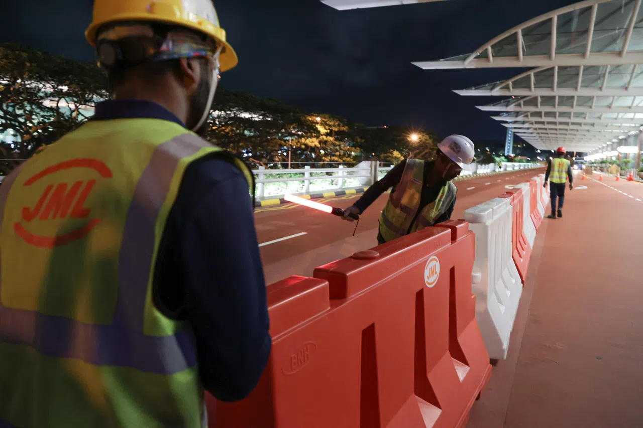 工作人员摆放路障，施工期间暂时关闭两条车道。（李冠卫摄）