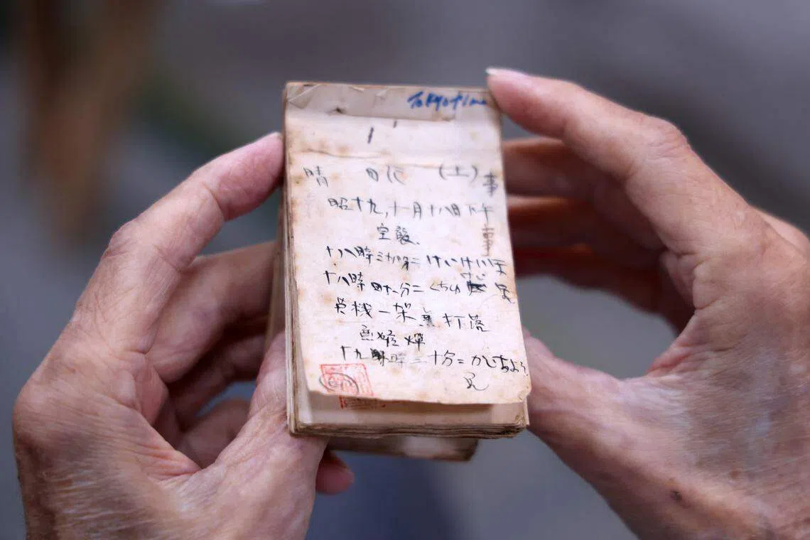 陈加昌在第二次世界大战新加坡被日军占领期间，用随身的小本子记录了轰炸机飞过和防空警报响起的日期与时间。他2022年2月应邀到报馆参加一场纪念新加坡沦陷80周年的跨时代对话时，向早报读者展示了这些珍贵的历史记录。（档案照片）