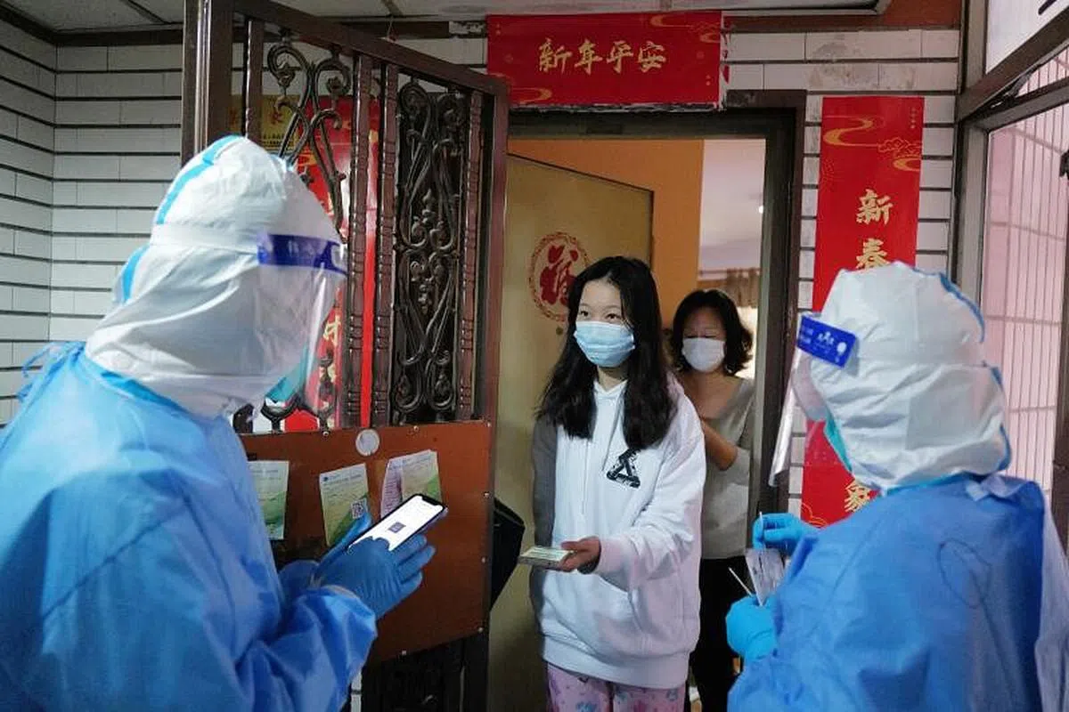 在深圳南山区一封控小区，医护工作人员今天（14日）逐家逐户上门为居家隔离市民做核酸检测。（中通社）