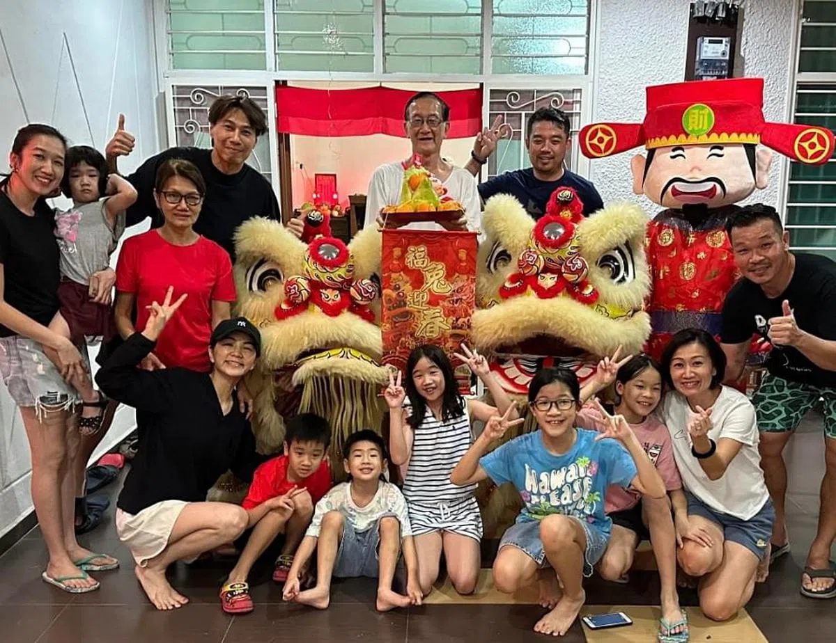 Ella（前排左一）入乡随俗，与家族成员开心与醒狮、财神爷合照。（互联网）