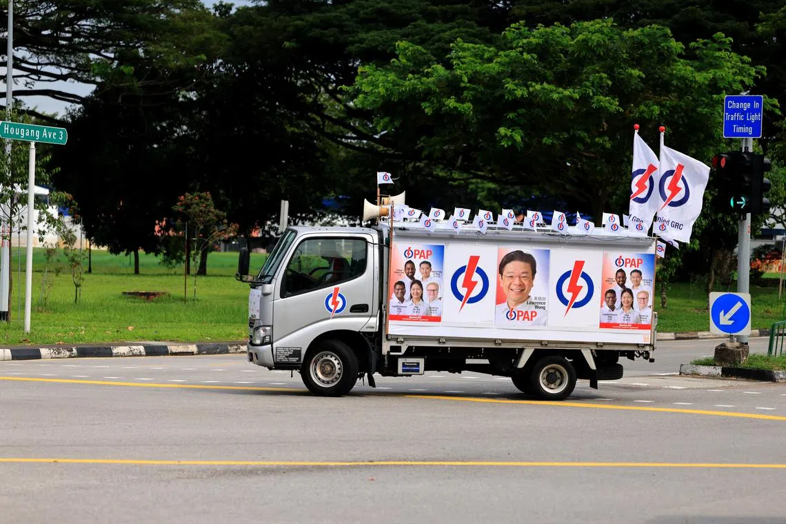 行动党阿裕尼集选区团队在提名后开始竞选活动。图为一辆贴有团队头像的海报在路上行驶。（龙国雄摄）