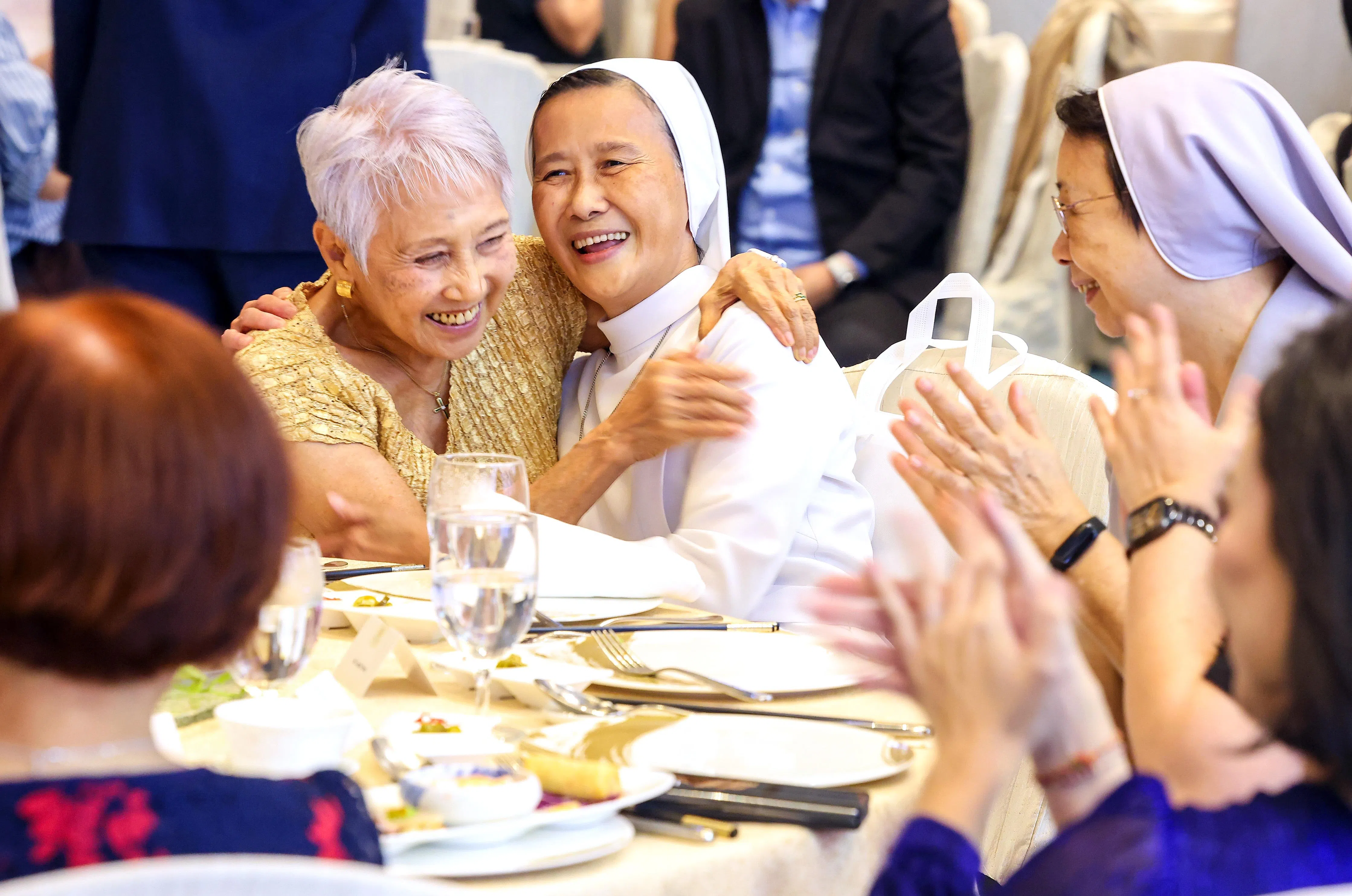 另一名荣获“新加坡慈怀终身成就奖”的获奖者陈瑞云修女（左二）与新加坡慈怀理事会首任主席薛爱美（左一）相拥庆祝。（陈斌勤摄）
