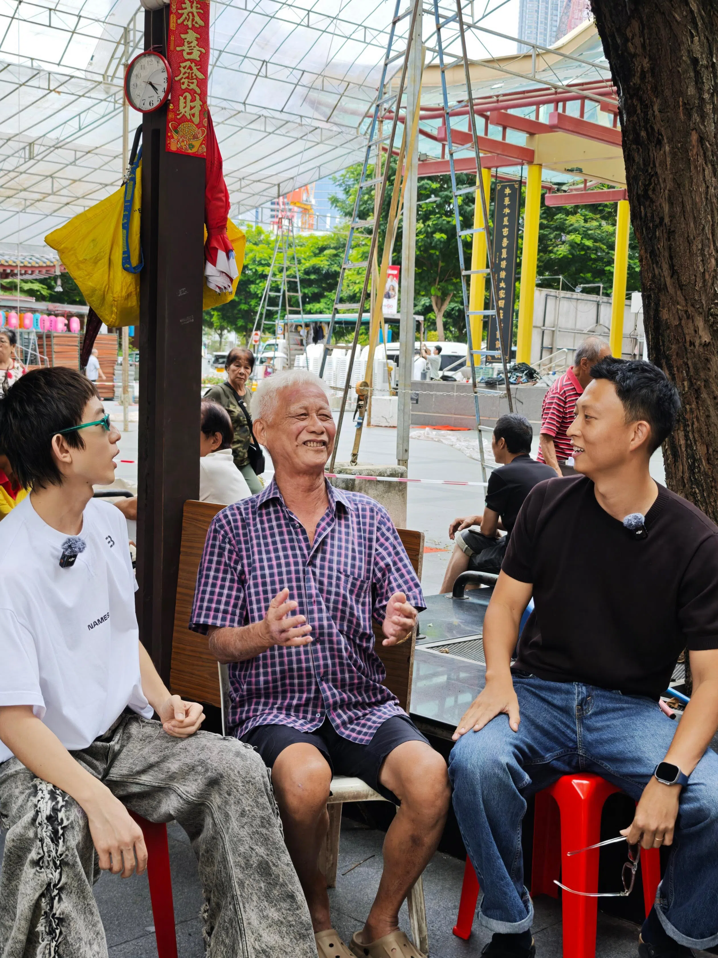 托哥（右）和台湾歌手林宥嘉（左）一起在牛车水做街访。（受访者提供）