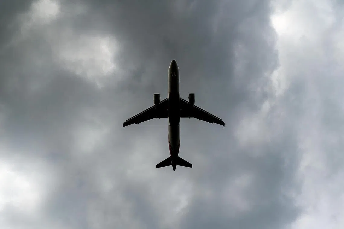 飞机越过厚重云层，向更明亮的天空前行。（关俊威摄）