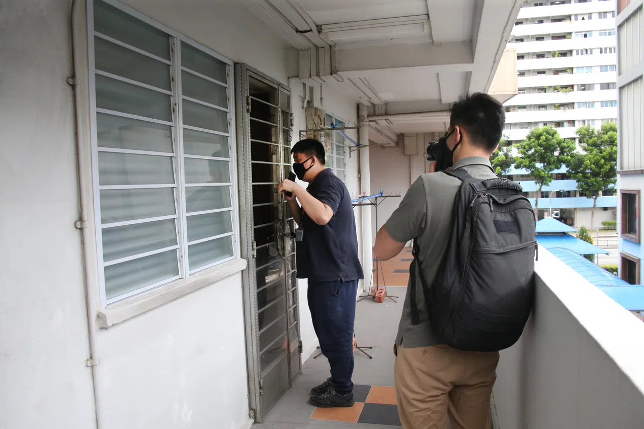 为了保持安全距离，高级记者王康威在疫情期间站在受访者住家门外进行采访。（档案照片）