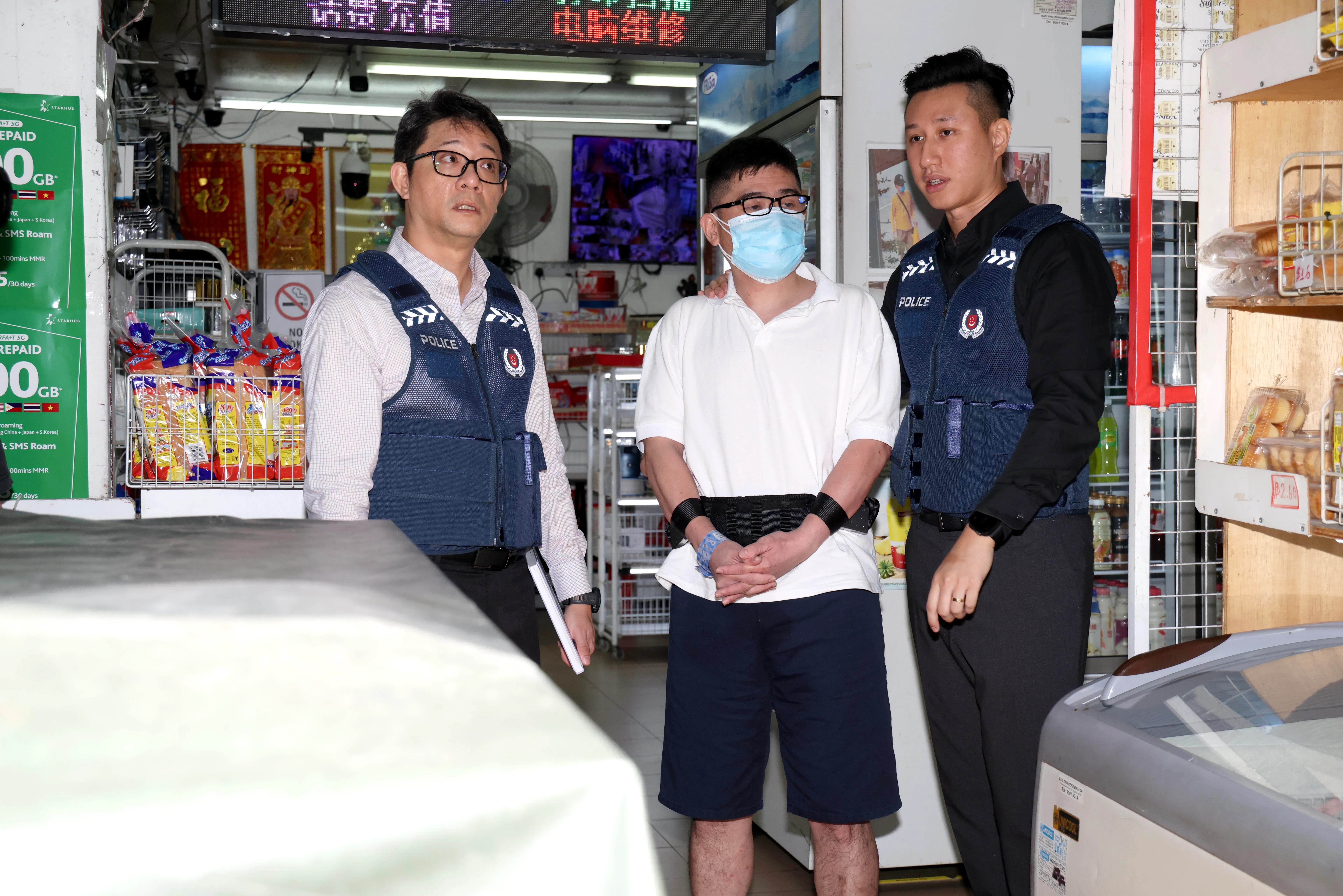 新加坡籍男子杨健达被警方押回干案现场。（郑一鸣摄）