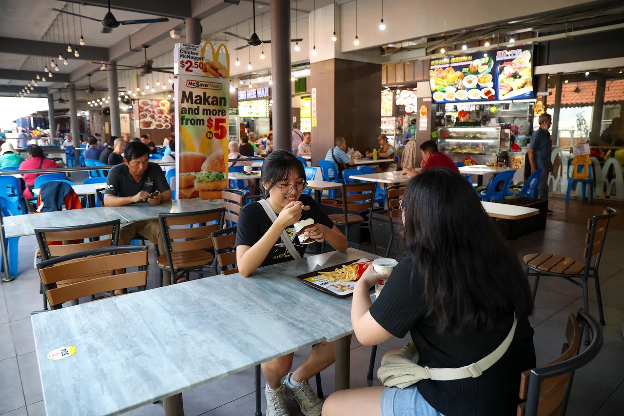 经过一天的游览，覃竖荑（左）与黄佳韵（右）在巴刹附近的麦当劳，边吃边聊天。（关俊威摄）