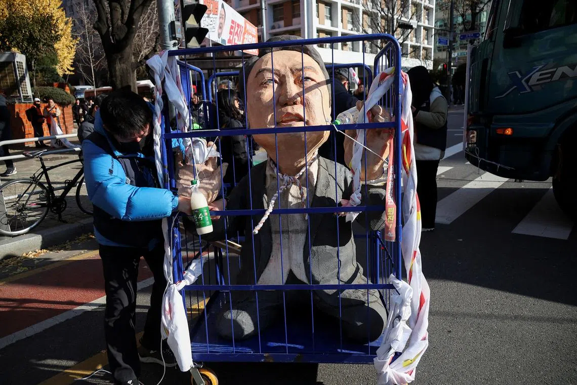 示威民众推着困于笼中的韩国总统尹锡悦肖像游行，呼吁弹劾尹锡悦。（路透社）