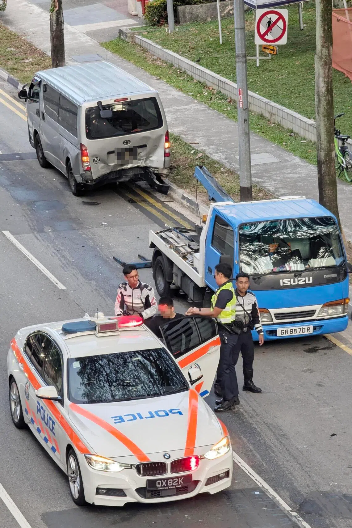 涉案男驾驶（黑衣）被押上警车，带回警局协助调查。（受访者提供）