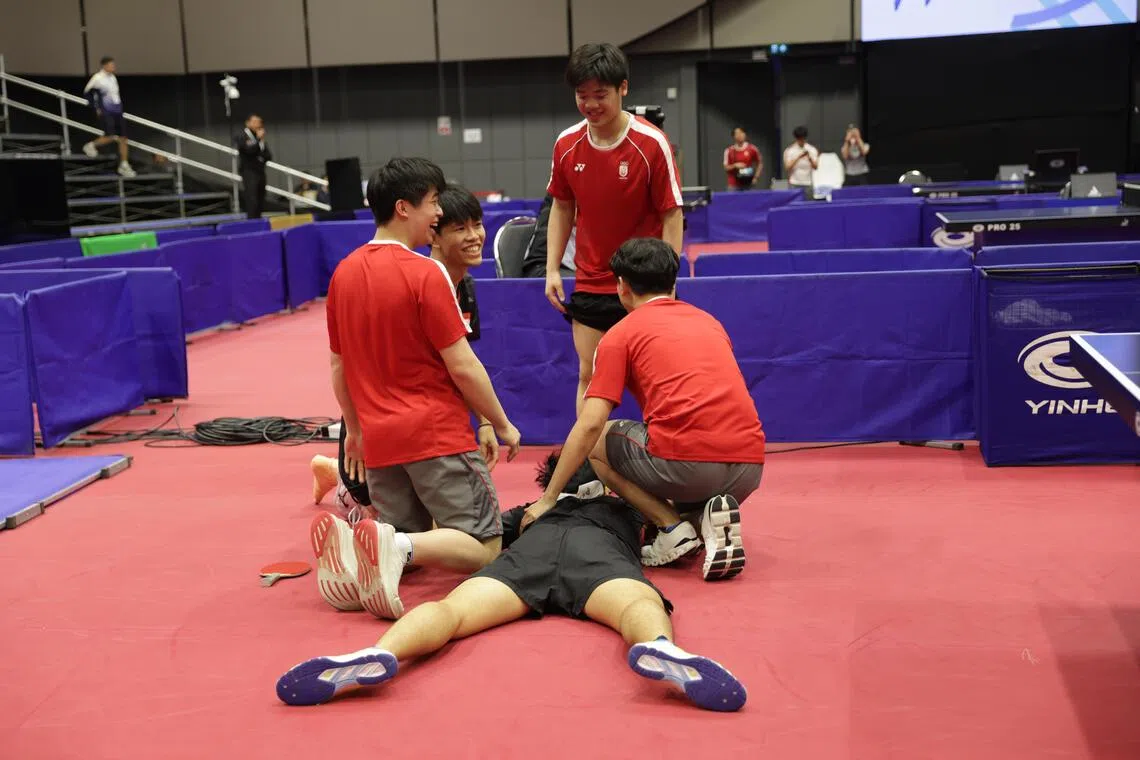 冯耀恩在胜出后趴在地上，其他队友们纷纷跑到他身旁一起庆祝，就连受伤后坐在医疗椅，和队友分开的蔡邵恒（左二）也一起跑来庆祝夺金。（白艳琳摄）