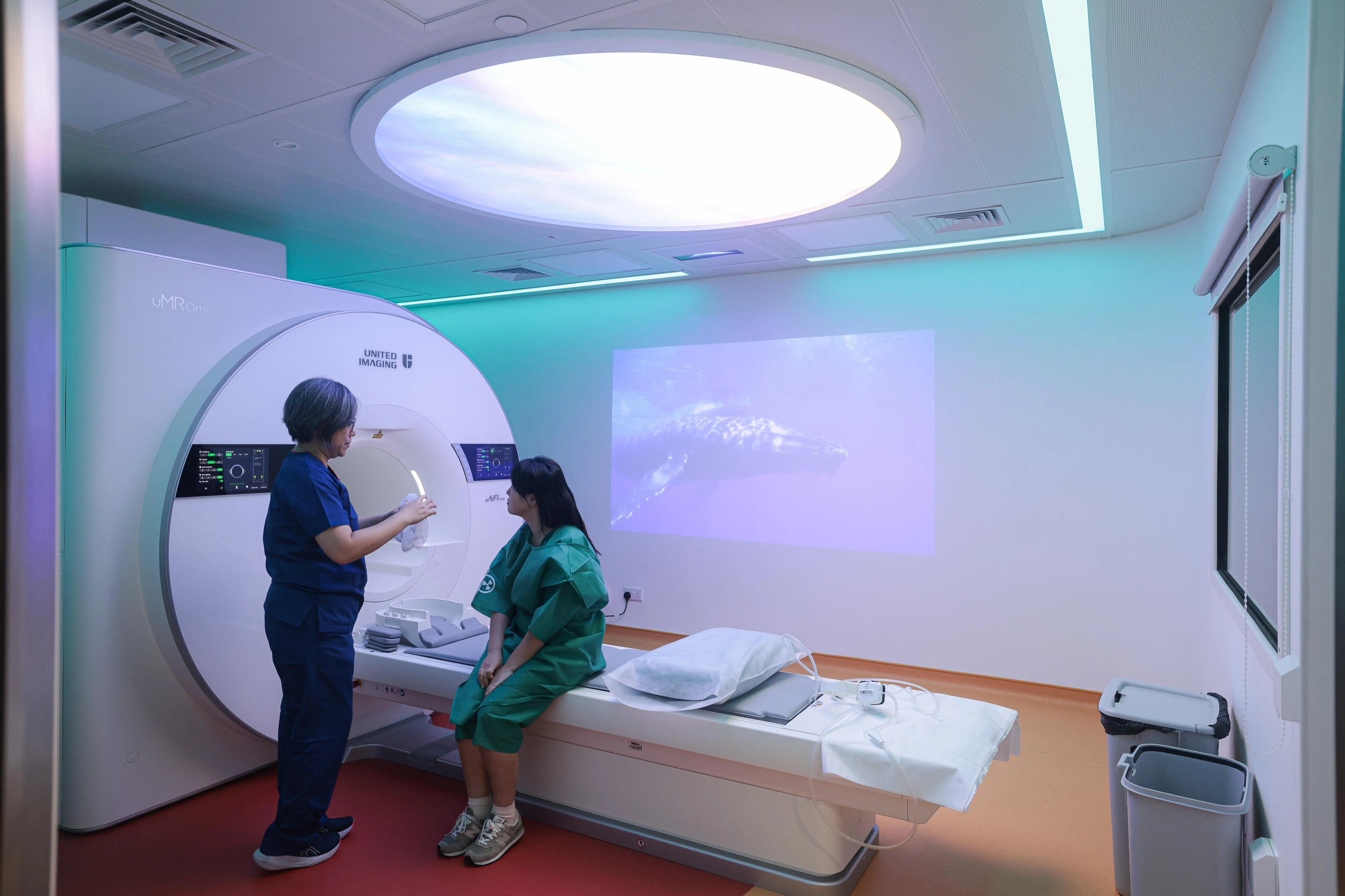 患者可选择播放自然景观等舒缓视频，并调整机器灯光颜色，使整体环境不再那么令人畏惧。（李冠卫摄）