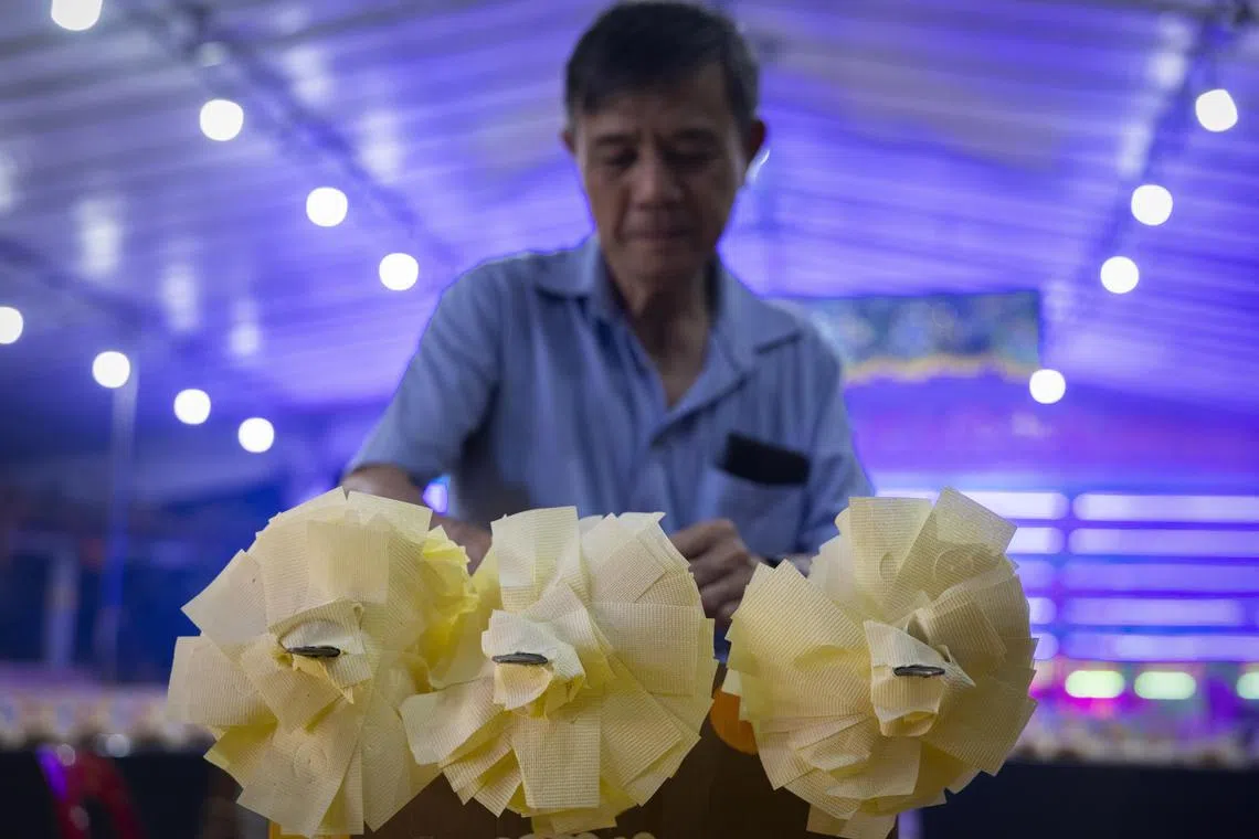 黎师傅在破地狱仪式开始前，将溪钱插在剑上。（龙国雄摄）