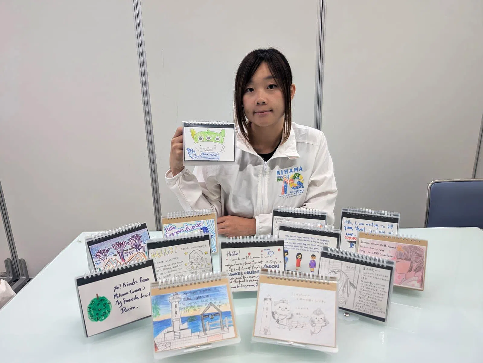 来自新加坡的林怡萱在美滨町工作已有五年，负责推动美滨町的国际交流事务。她和同事收集了许多新日两地交流学生的笔记与画作。（受访者提供）