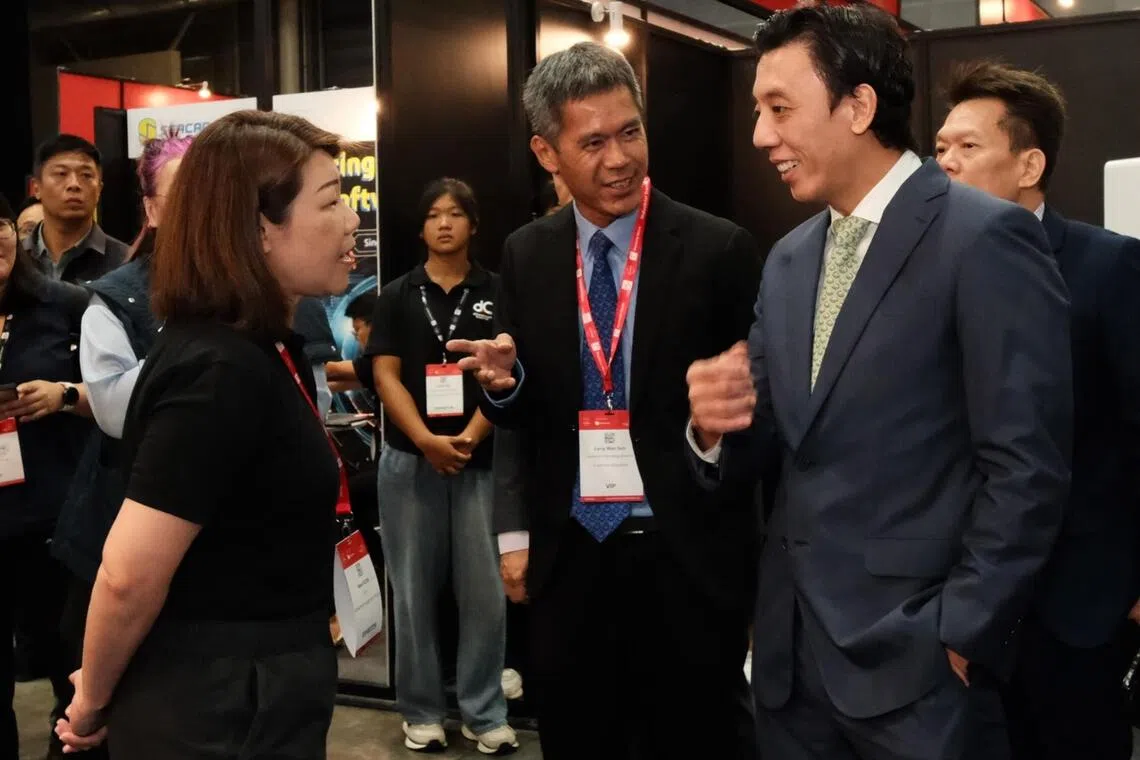萧振祥（右一）在第八届工业转型亚太区博览会上，与参展企业互动。（星域展览提供）