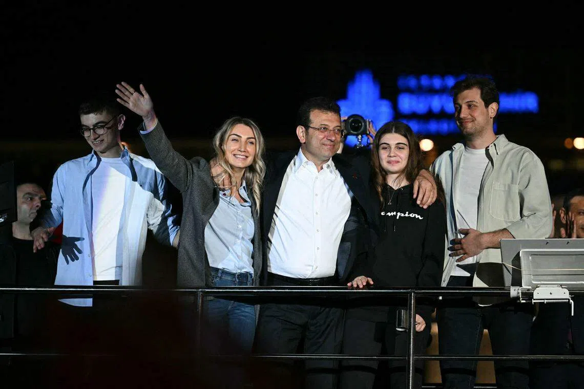 3月31日深夜，伊玛莫格鲁（中）与家人一起上台，向支持者发表讲话。（法新社）