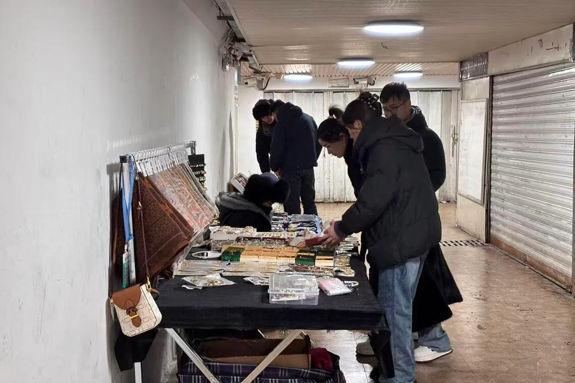 乌鲁木齐二道桥一处地下通道内，几名少数民族青年今年1月在摆摊售卖鞋垫、手表等商品。（黎康摄）