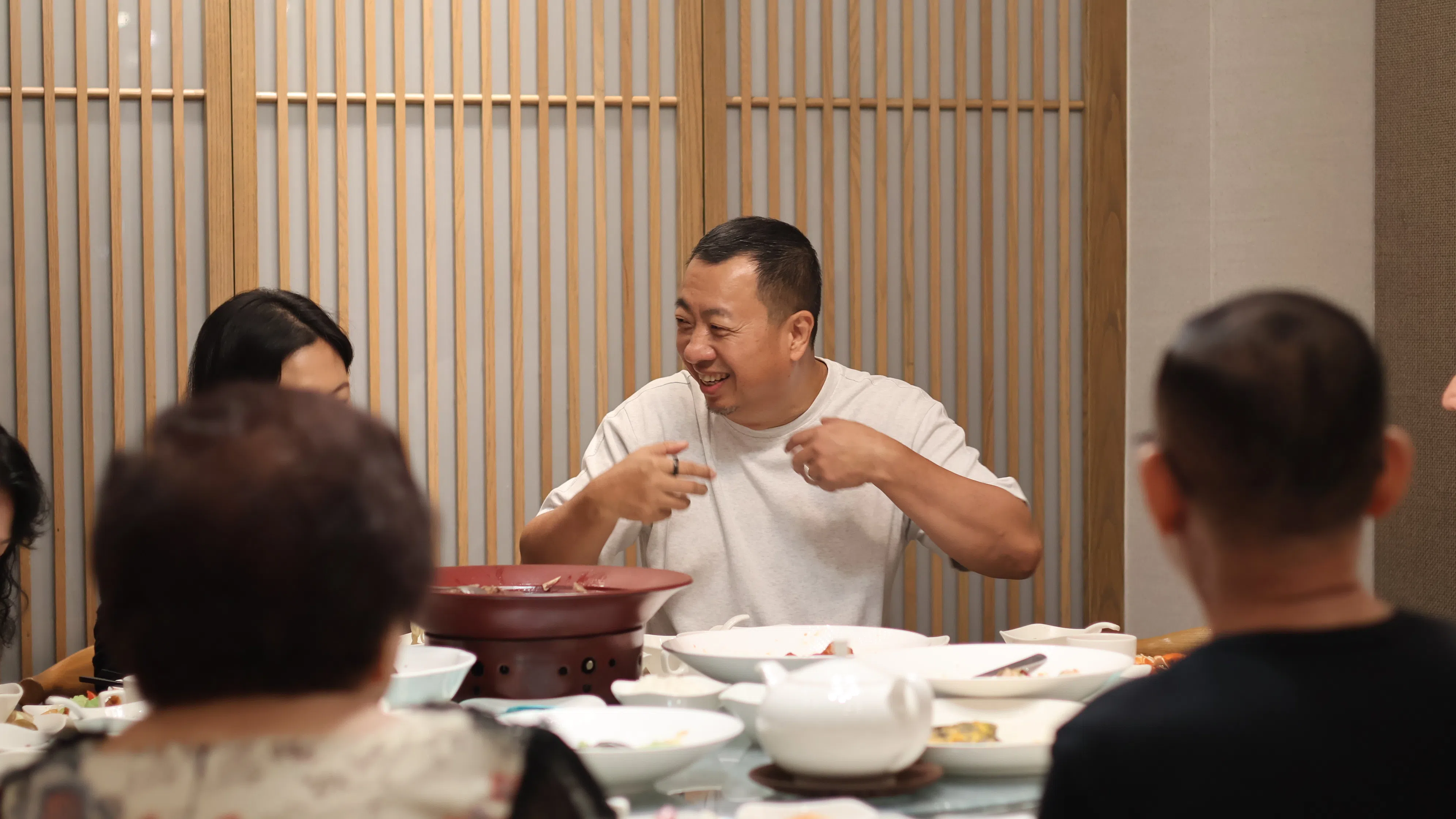 方志忠在创始店与一路相随的老朋友，相谈甚欢。他也打算安排从老店走出去的其他店长和厨师长，每年“回娘家”一周，了解老顾客的想法与期待。（餐馆提供）