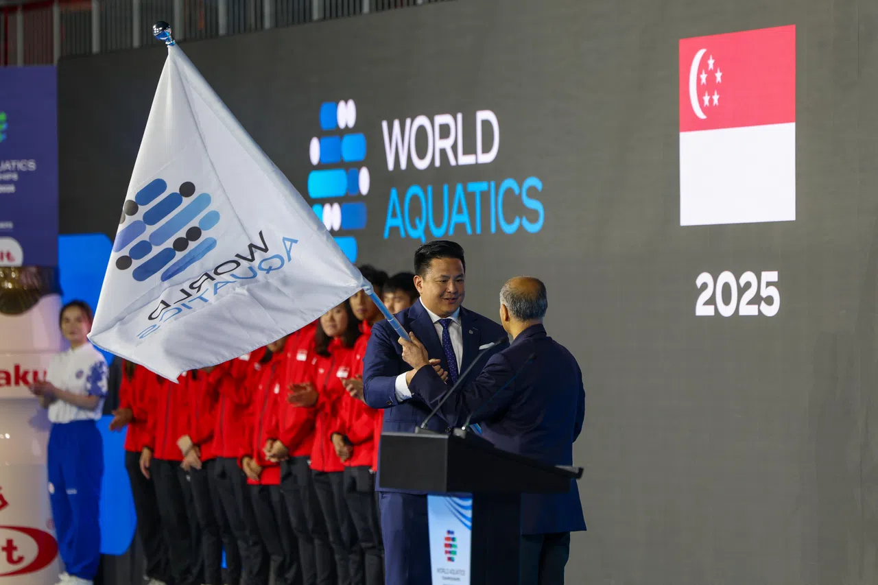 新加坡全国奥理会秘书长兼赛事组委会联合主席蔡荣俊（右二）将世界泳联旗帜交还给世界泳联主席阿尔—穆萨拉姆（右一），标志着第22届水上运动世锦赛在狮城的圆满结束。（白艳琳摄）