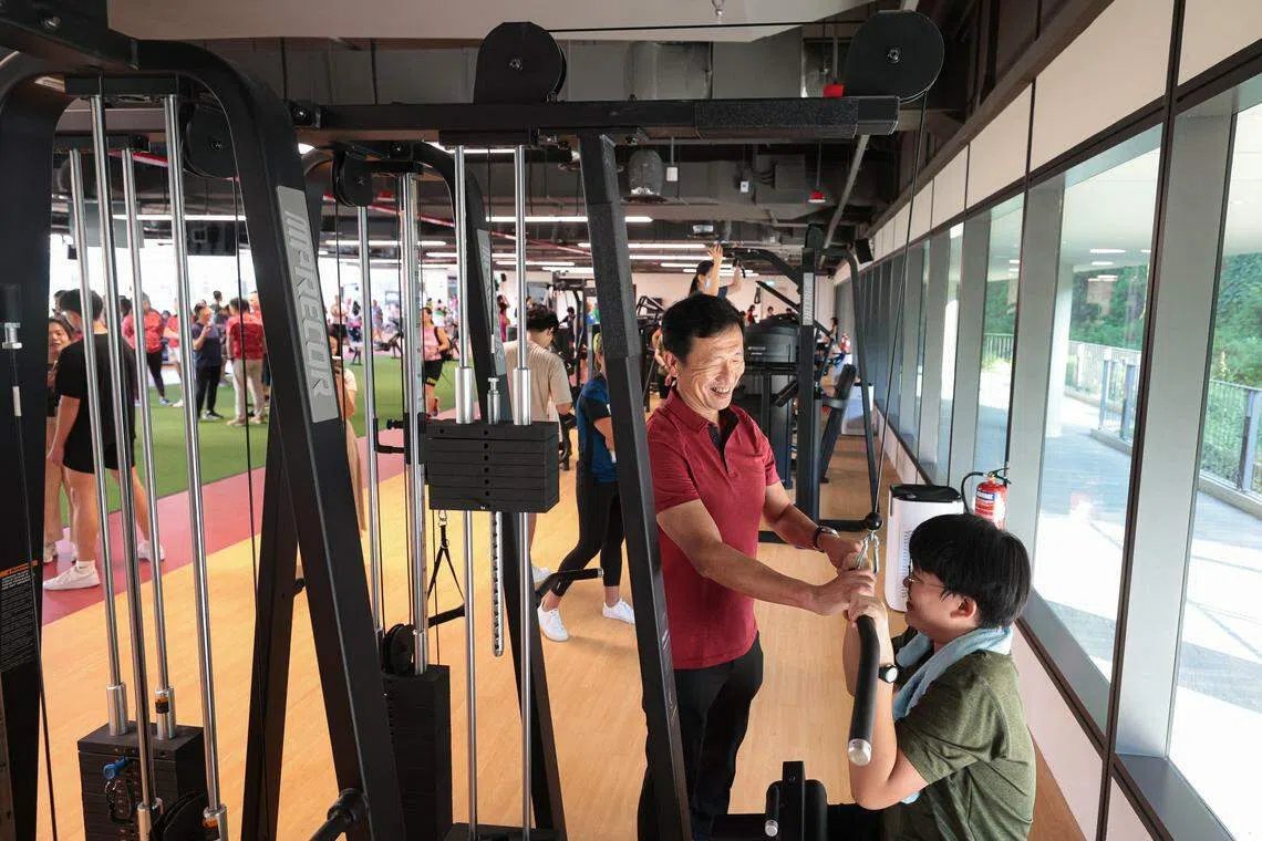 三巴旺集选区议员、卫生部长王乙康（红衣）在武吉坎贝拉综合中心新开幕的ActiveSG健身房内与居民交流。（李冠卫摄）