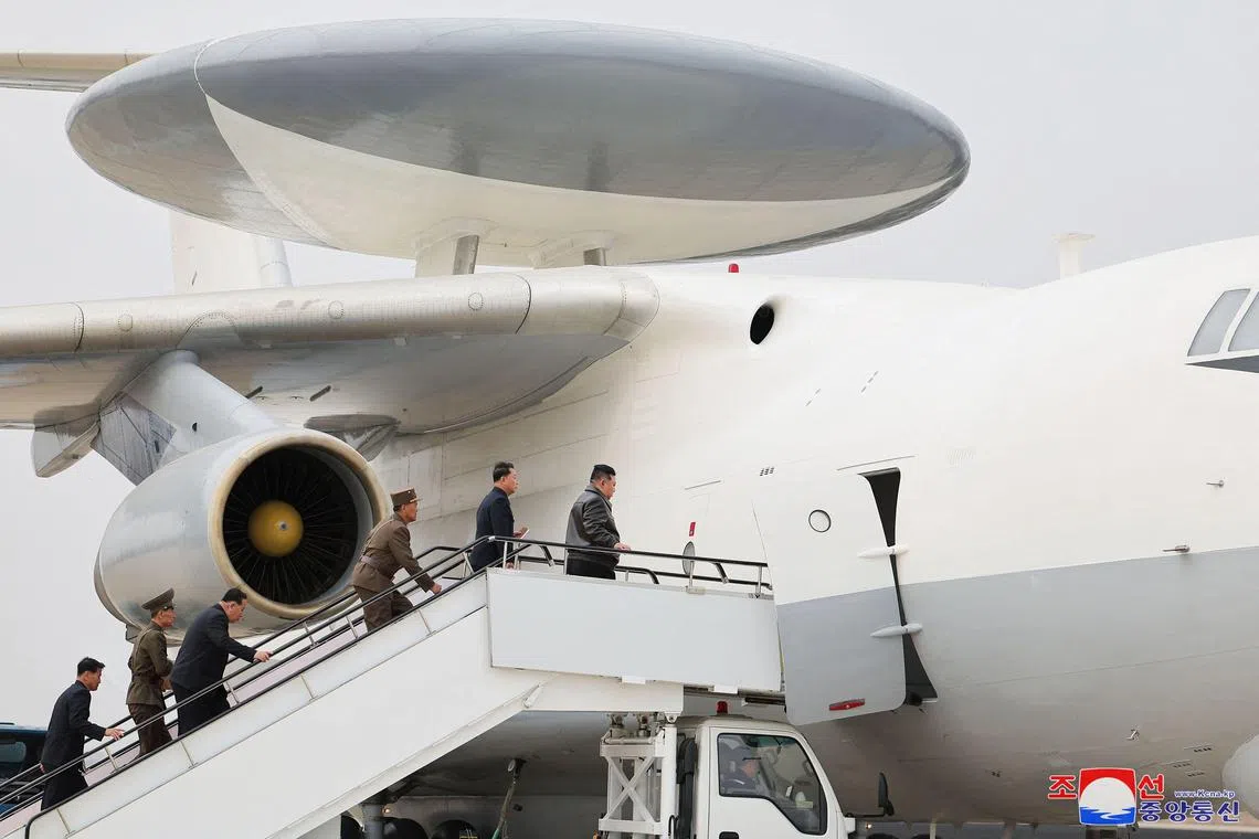 朝中社的照片显示，金正恩（右一）搭乘与韩国空军“和平之眼”空中预警机类似的飞机，多名朝军干部尾随在后。（法新社）