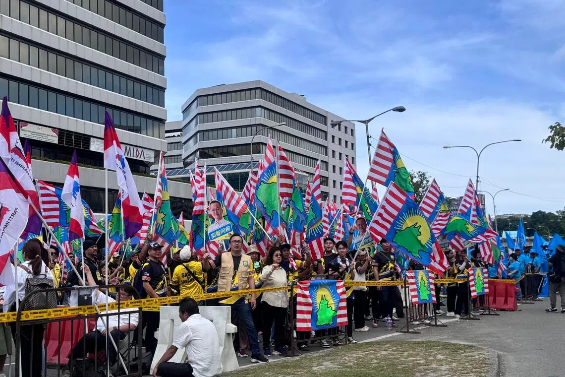 在亚庇提名中心，多个沙巴本土政党的支持者挥舞党旗，高喊“沙巴人的沙巴”口号。（萧郡瑜摄）