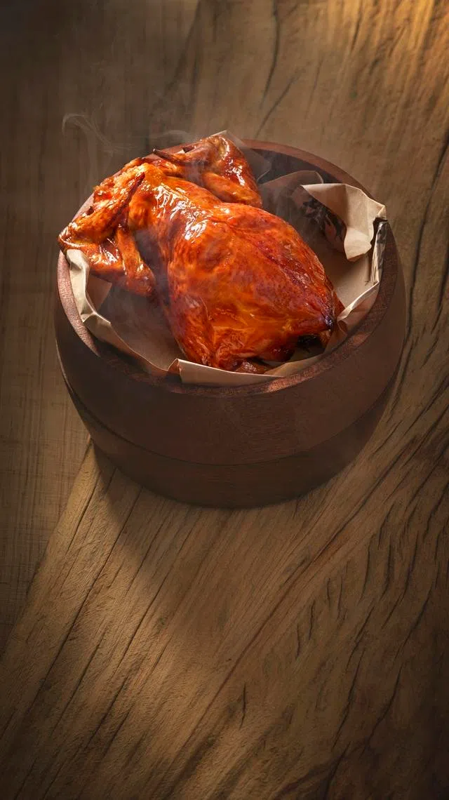 龙井烤鸡，外皮金黄酥脆，茶香浓郁四溢。（餐馆提供）