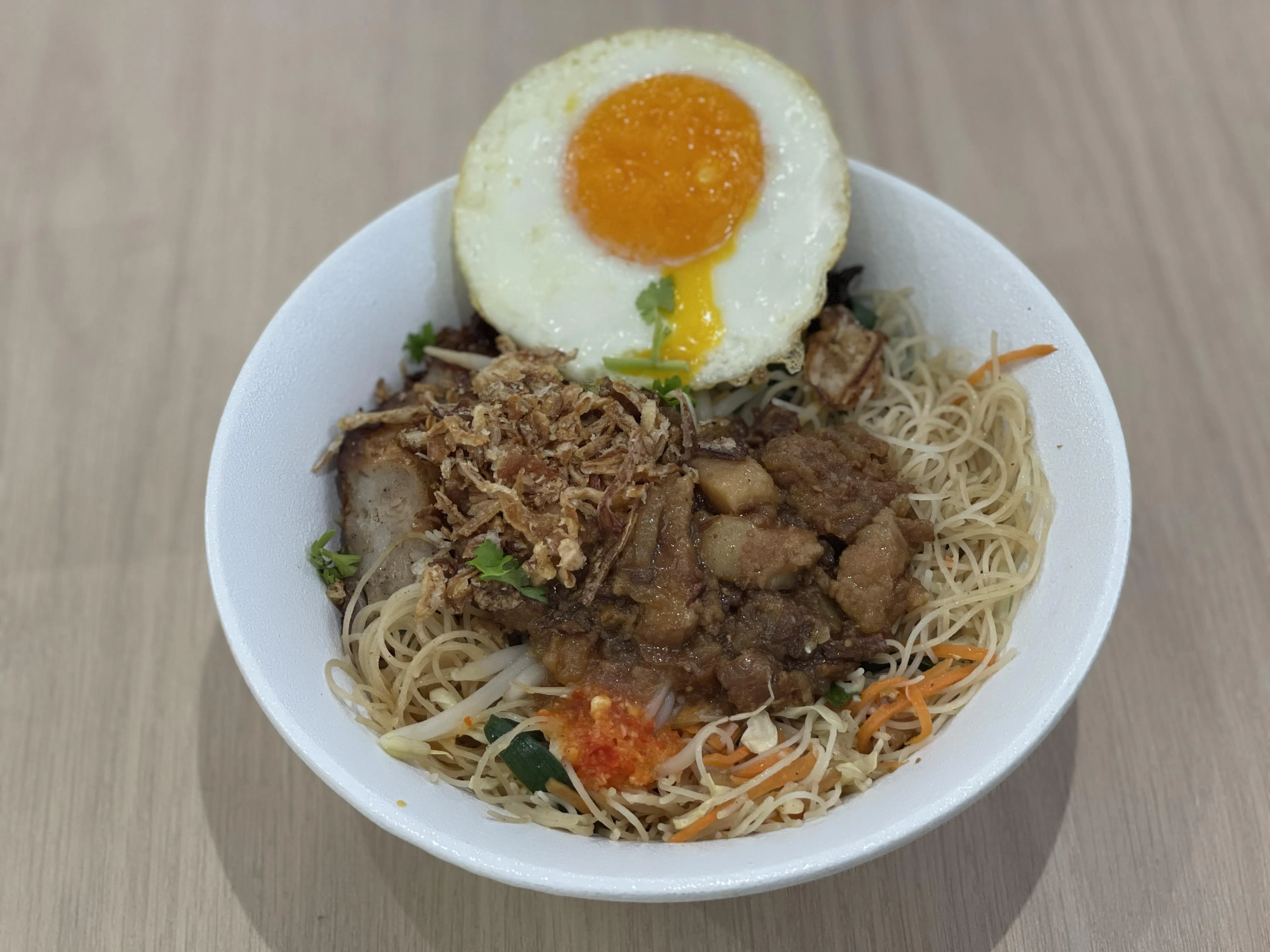 台式炒米粉，堆满煎荷包蛋、卤肉碎、炸五香等配料。（黄靖晶摄）